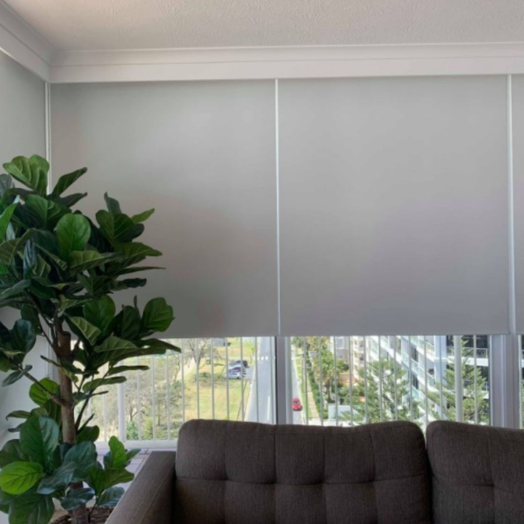 Partially lowered blinds above a couch - best window coverings to keep the heat out blog featured image