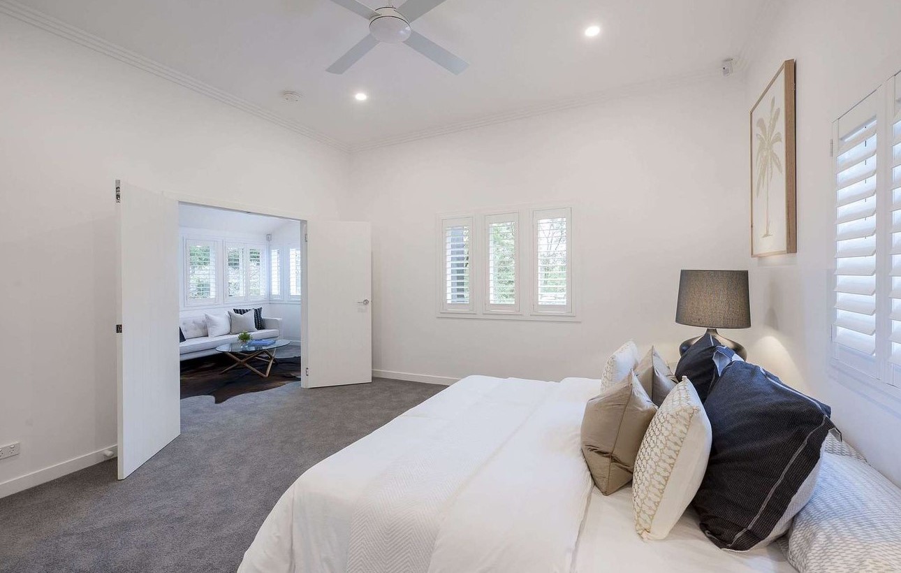 A bedroom with shutters in the windows