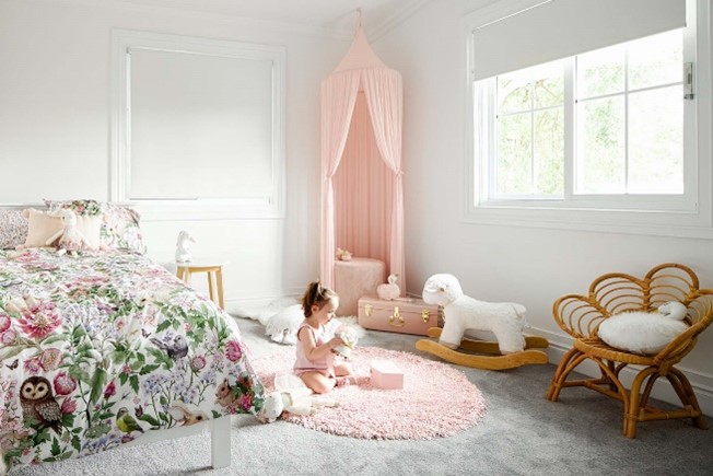 White walled room with a baby sitting on a peach coloured rug | Featured image for Beachy Interior Design: Creating the Ultimate Coastal Look.