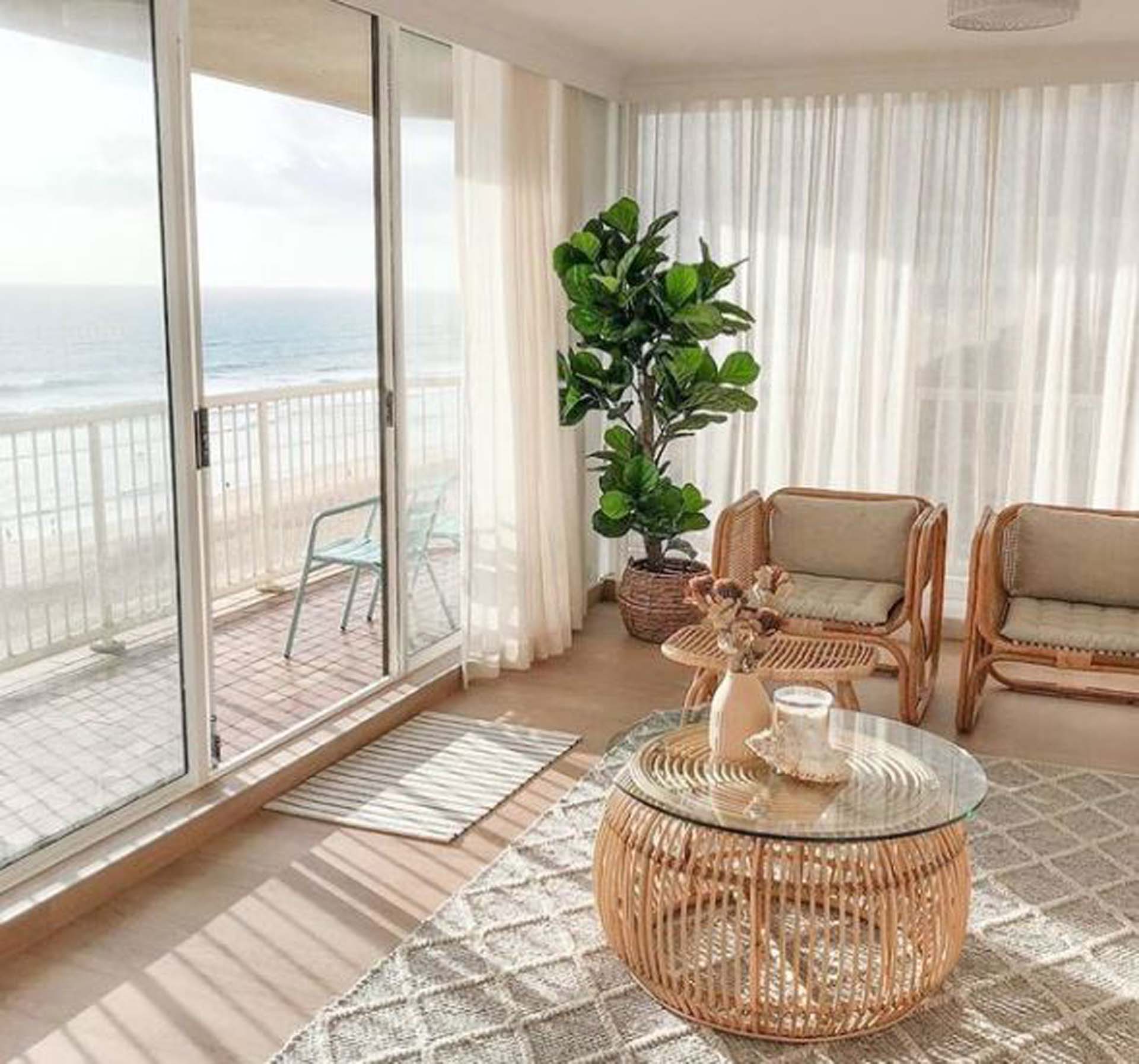 Living room with glass sliding door looking out over the ocean | Featured image for Bohemian Interior Design: A Decorator's Guide to All Things Boho. - Featured image for Bohemian Style Interior Design blog