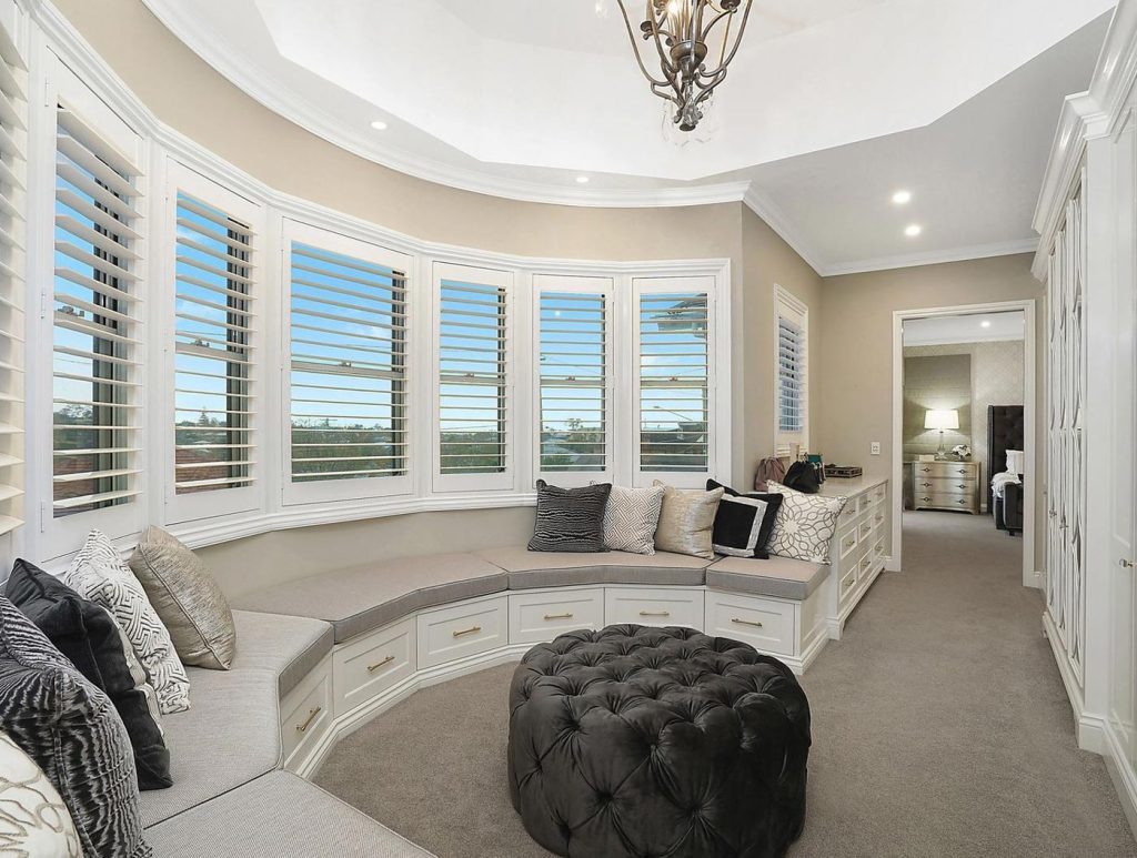 PVC Shutters in a bay window seating area | Featured image for the Most Insulating Shutters blog post from Blindo.