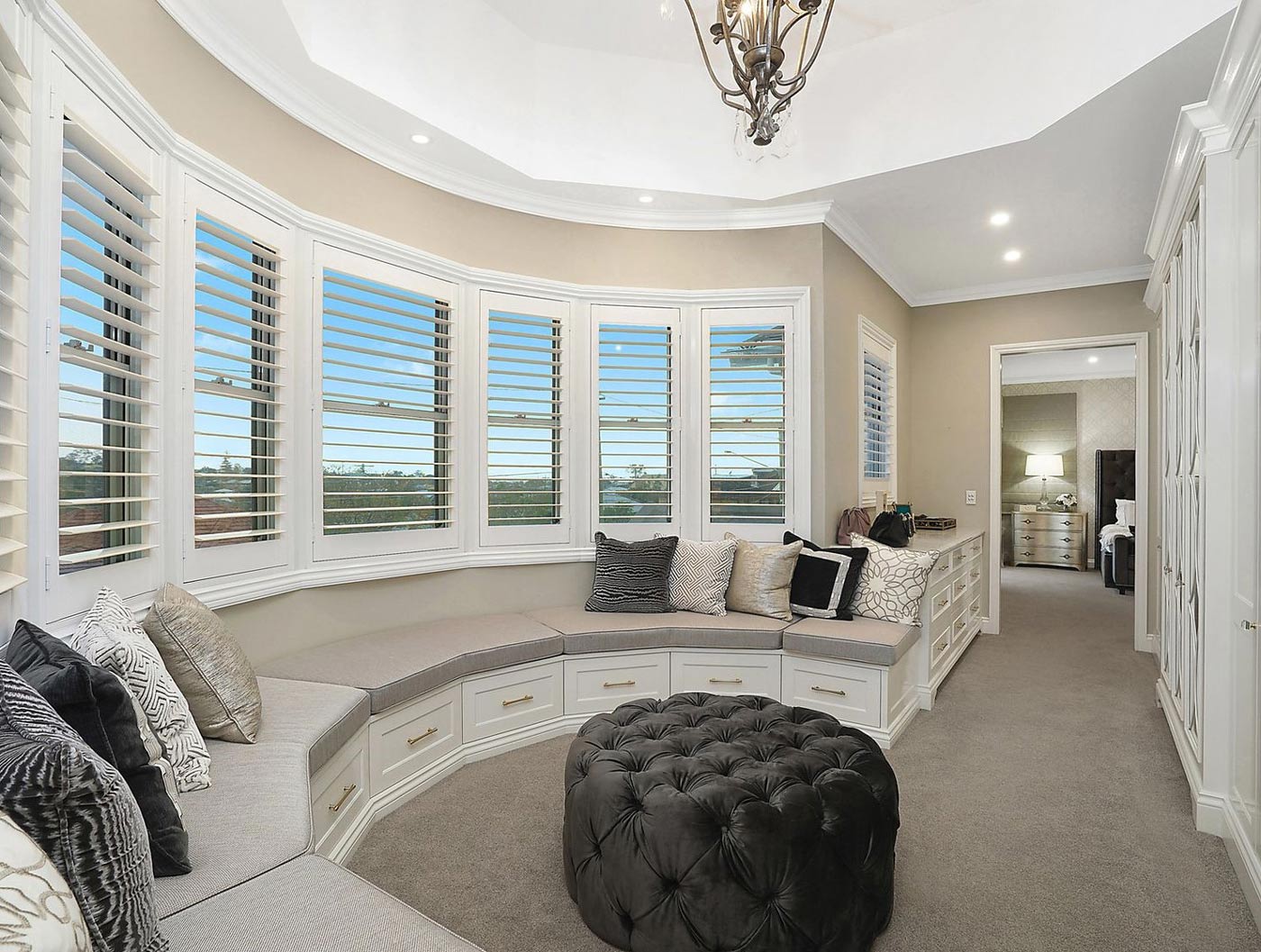 PVC Shutters in a bay window seating area | Featured image for the Most Insulating Shutters blog post from Blindo.